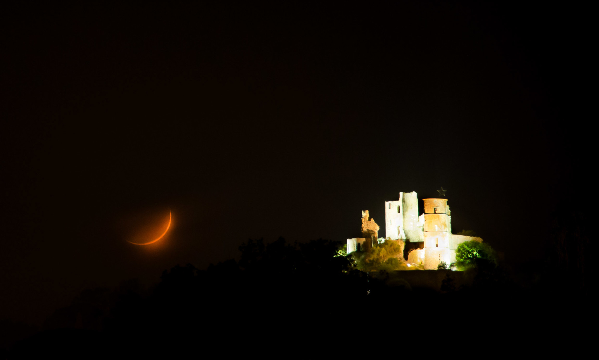 Moon setting through the clouds over Grimaud Castle